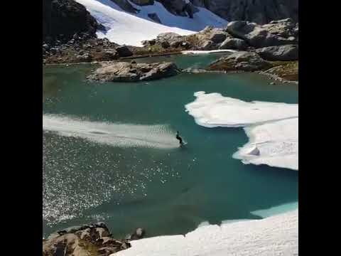 Guy Skis Down Glacier and Skims Across Lake - 990171